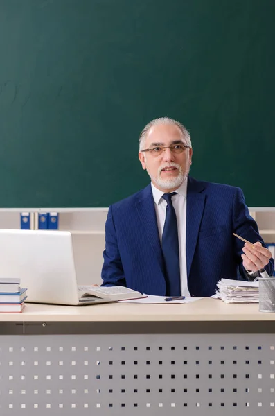 Leeftijd mannelijke leraar in de voorkant van schoolbord — Stockfoto