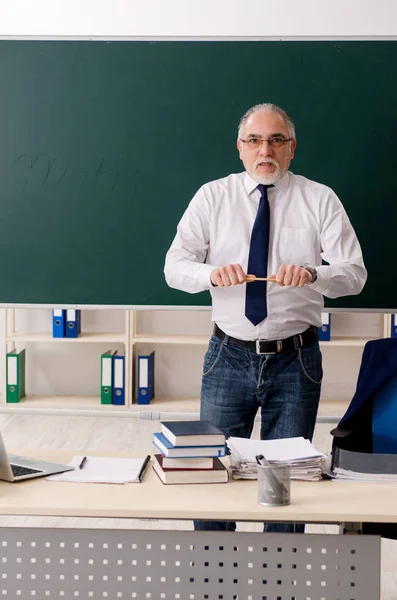 Leeftijd mannelijke leraar in de voorkant van schoolbord — Stockfoto