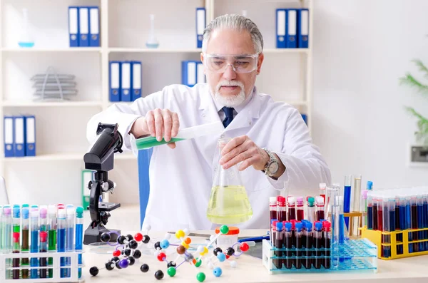 Старий хімік-чоловік працює в лабораторії — стокове фото