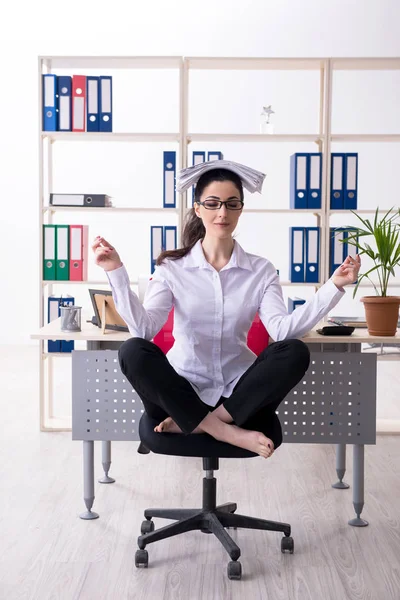 Young female employee doing exercises in the office