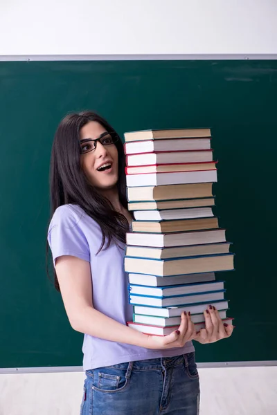 Jonge vrouwelijke leraar student in de voorkant van green board — Stockfoto