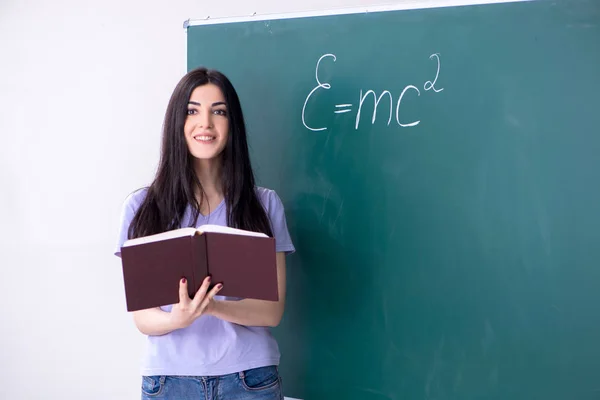 Ung kvinnlig lärare student framför green board — Stockfoto