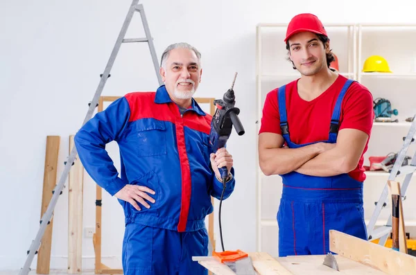 Two professional contractors laying flooring at home