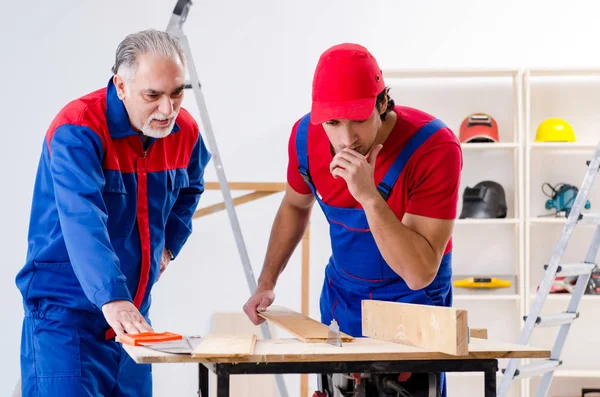 Two professional contractors laying flooring at home