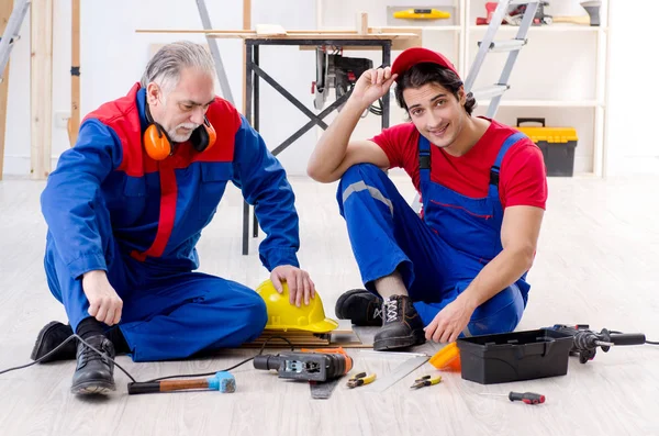 Two professional contractors laying flooring at home