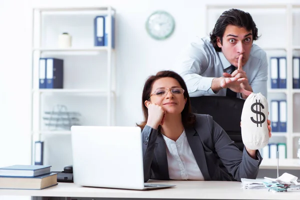 Old female boss and young male employee in the office