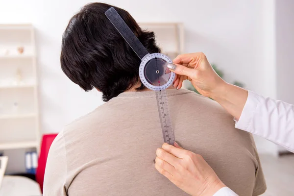 Médecin féminin vérifiant la flexibilité articulaire des patients avec goniomètre — Photo