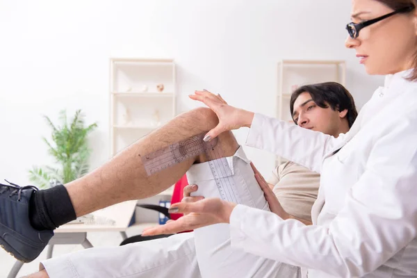 Kvinnlig läkare kontrollerar patienter ledflexibilitet med goniometer — Stockfoto