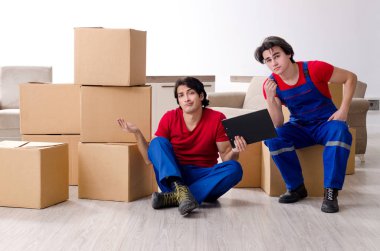 İki genç müteahhit kişisel eşyalarını taşıyor.