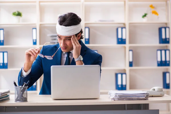 Head injured male employee working in the office