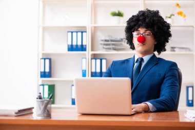 Genç palyaço işadamı ofiste çalışıyor. 