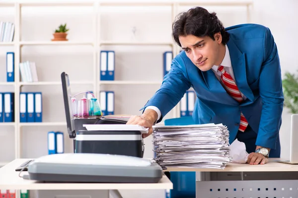 Joven empleado haciendo copias en la copiadora — Foto de Stock