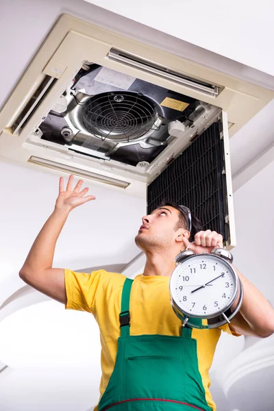 Jonge reparateur repareert airconditioning aan het plafond — Stockfoto