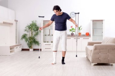 Evde acı çeken bacağı yaralı genç adam. 