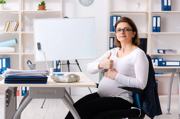 Vecchia donna incinta che lavora in ufficio — Foto Stock