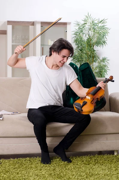 Mladý hudebník muž cvičí doma na housle — Stock fotografie