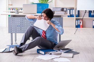 Genç bir erkek işçi aşırı işten memnun değil. 