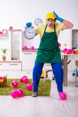 Genç erkek müteahhit partiden sonra ev işi yapıyor. 