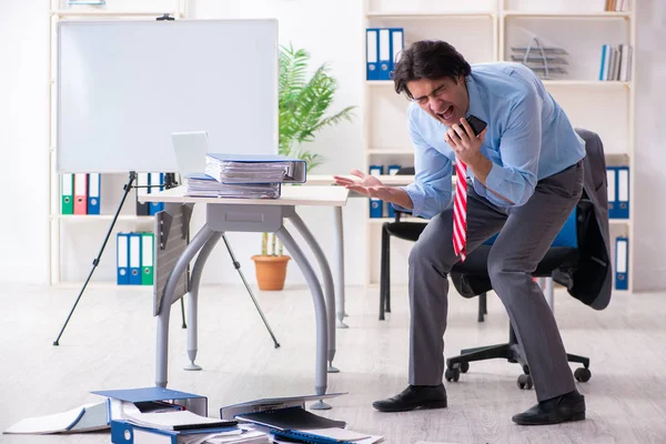 Giovane dipendente maschio infelice con il lavoro eccessivo — Foto Stock