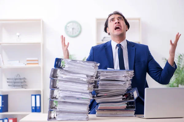 Young male employee unhappy with excessive work — Stock Photo, Image