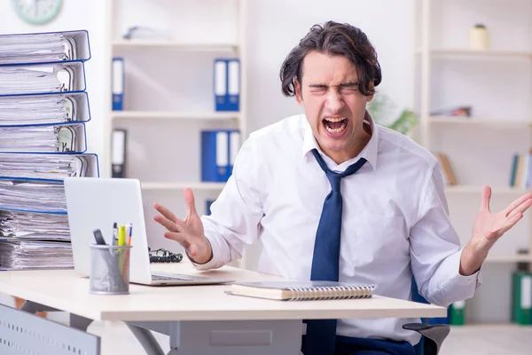 Young male employee unhappy with excessive work — Stock Photo, Image