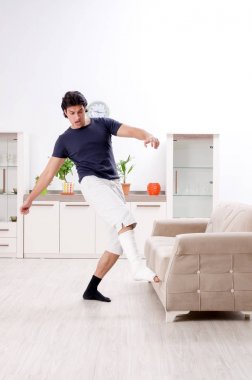 Evde acı çeken bacağı yaralı genç adam. 