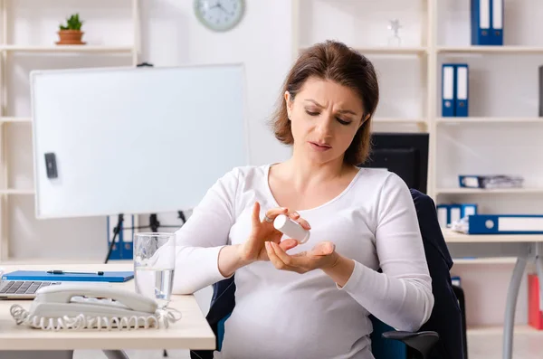 Vieille femme enceinte travaillant dans le bureau — Photo