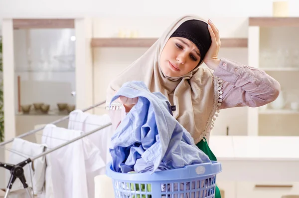 Mujer en hijab haciendo planchado de ropa en casa — Foto de Stock