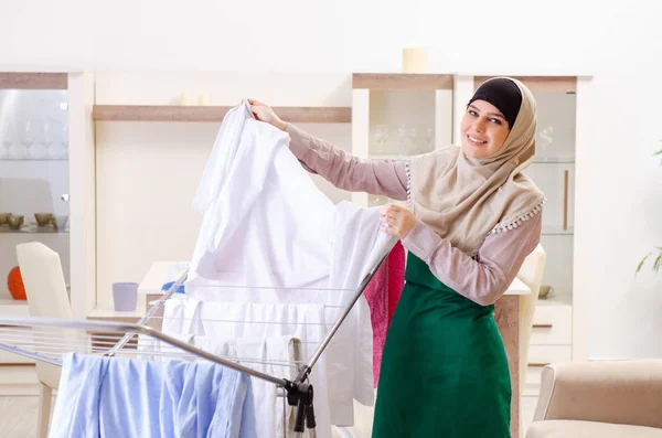 Kvinna i hijab gör kläder strykning hemma — Stockfoto