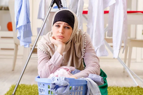 Frau im Hijab bügelt zu Hause Kleidung — Stockfoto
