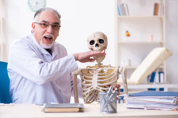 Homme âgé médecin avec squelette — Photo