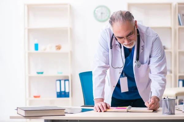 Viejo médico que trabaja en la clínica — Foto de Stock