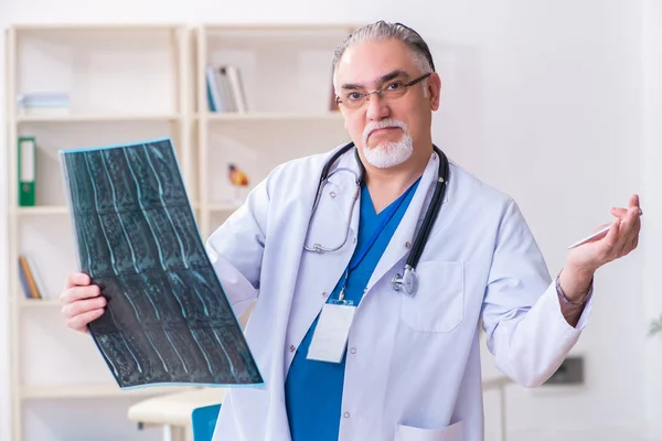 Klinikte çalışan yaşlı erkek doktor. — Stok fotoğraf