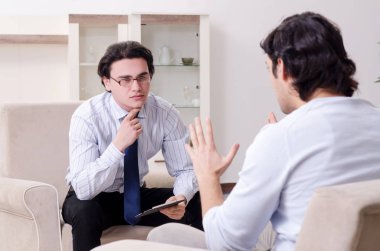 Genç erkek hasta psikologla kişisel sorunları tartışıyor.