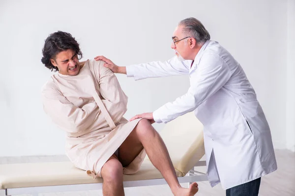 Aged male doctor psychiatrist examining young patient — Stock Photo, Image