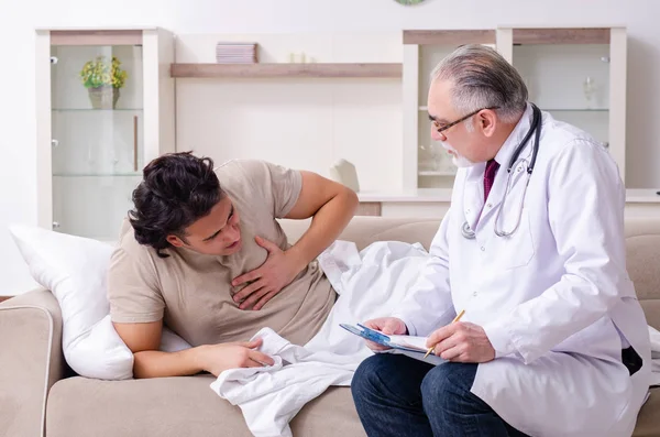 Yaşlı erkek doktor genç erkek hastayı ziyaret ediyor. — Stok fotoğraf