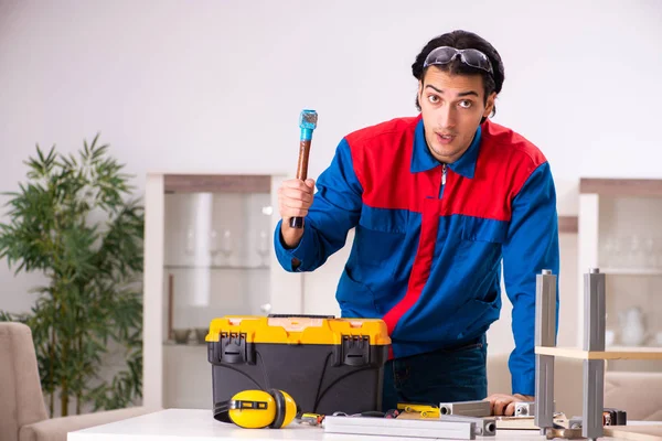 Young contractor repairing furniture at home