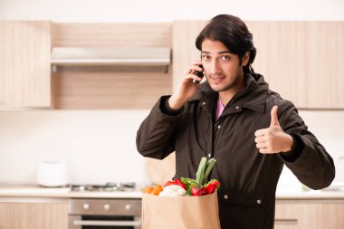 Yakışıklı delikanlı mutfakta sebze ile 