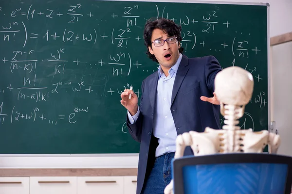 Joven profesor de matemáticas masculino y esqueleto de estudiante —  Fotos de Stock