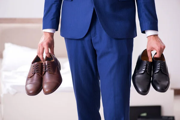 Jovem empresário bonito escolhendo sapatos em casa — Fotografia de Stock