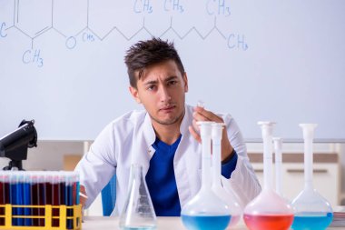 Laboratuarda oturan genç kimyager 