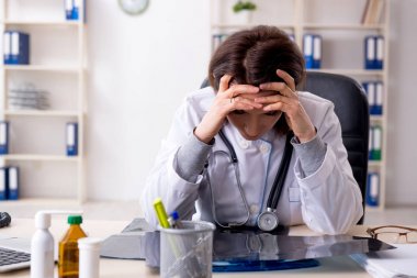 Klinikte çalışan yaşlı bir kadın doktor. 
