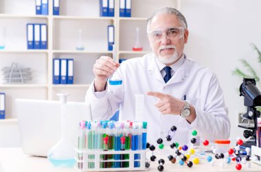 Laboratuvarda çalışan yaşlı bir kimyager. 