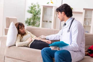 Genç, yakışıklı doktor, kadın hastayı evinde ziyaret ediyor. 