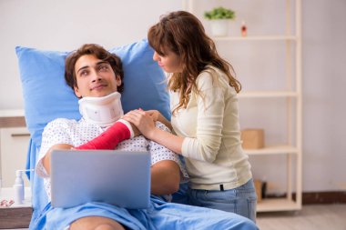 Hastanede yaralı kocayla ilgilenen sevgili bir eş. 