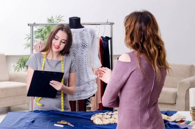 Genç, güzel bayan terzi ölçü alıyor.  