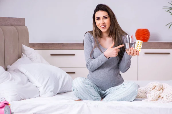 Jonge zwangere vrouw in de slaapkamer — Stockfoto