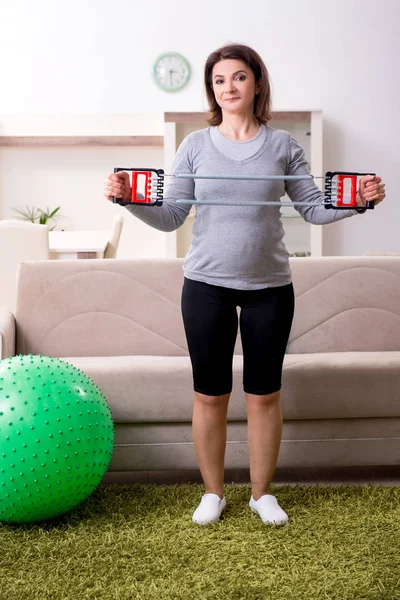 Mulher grávida envelhecida fazendo exercícios em casa — Fotografia de Stock