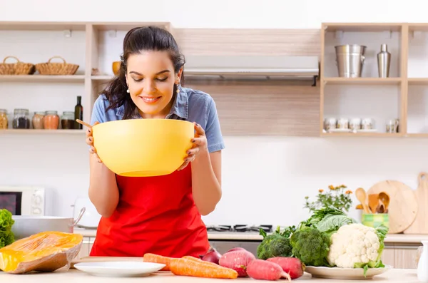 Mujer joven con verduras en la cocina — Foto de Stock