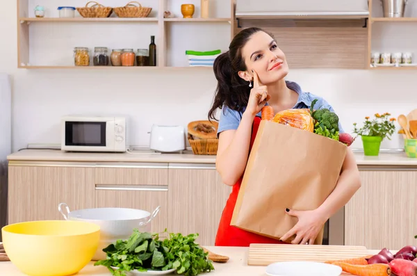 Giovane donna con verdure in cucina — Foto Stock